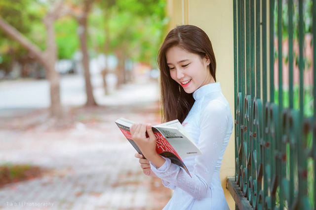 Nữ sinh ngồi đọc sách chăm chú