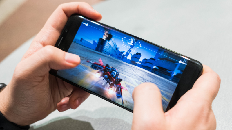 Minh họa việc game thủ mobile cần thao tác tay trên màn hình điện thoại